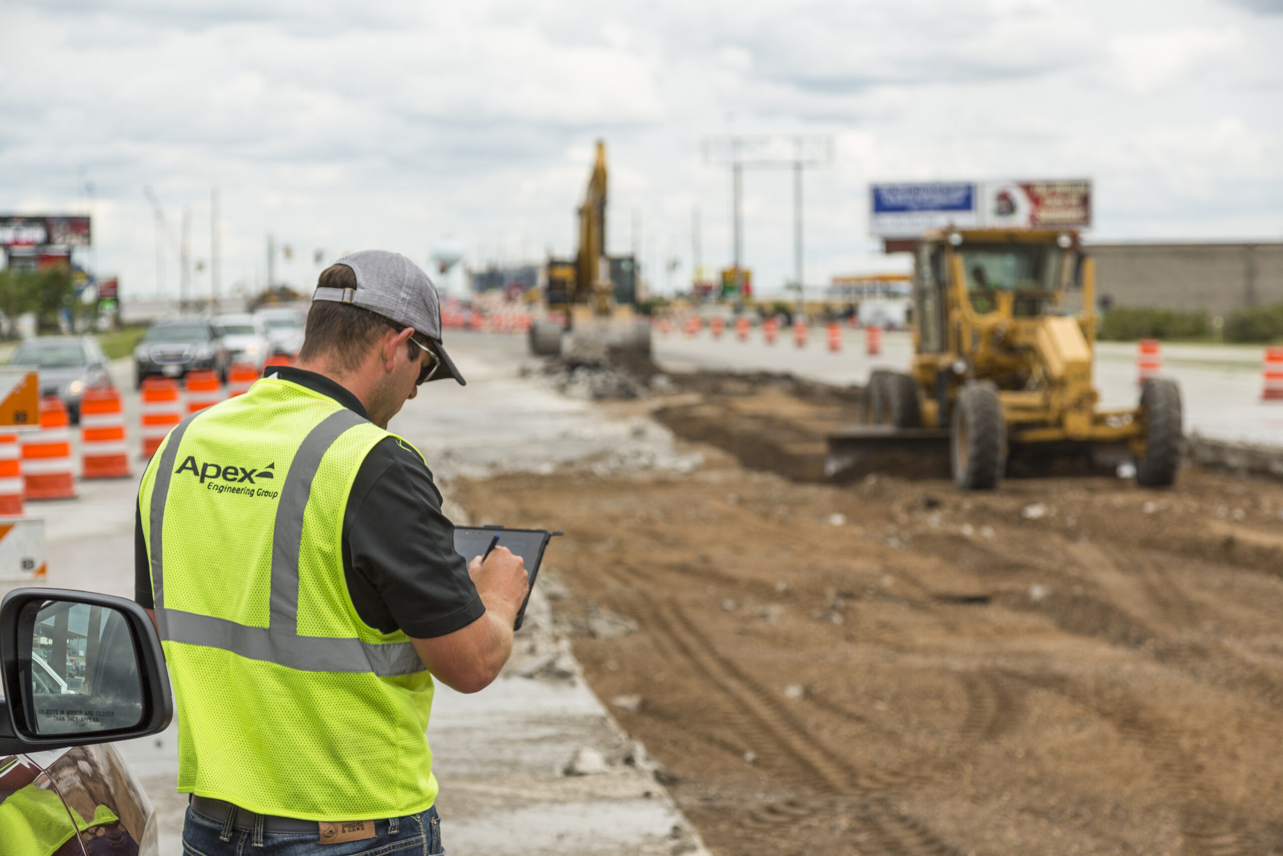 An Apex Engineer employee works on site during a road construction project.
