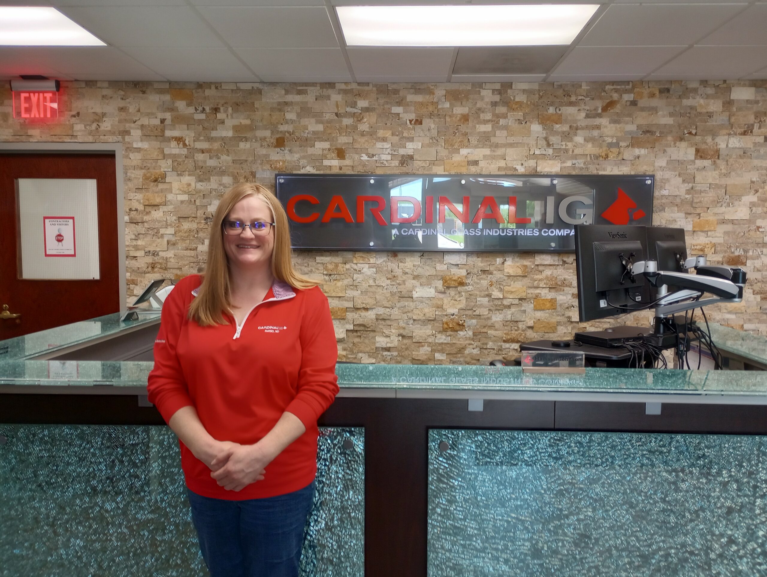 The Cardinal IG safety manager stands in front of the company's logo.