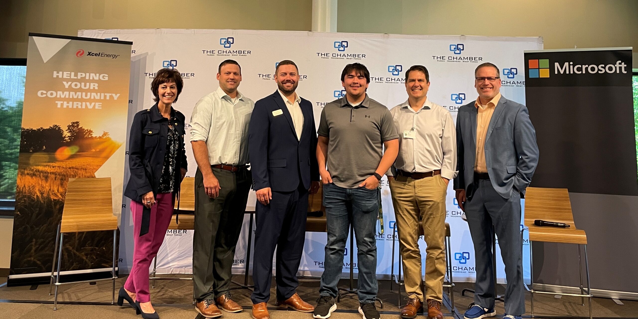 Chamber Group A group of six business professionals pose for a photo on the stage at an FMWF Chamber event about work-based learning