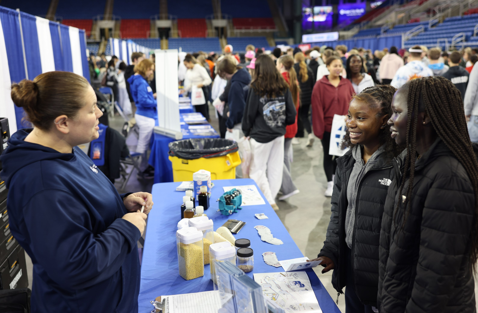 Two students visit with an American Crystal Sugar employee at a career fair table