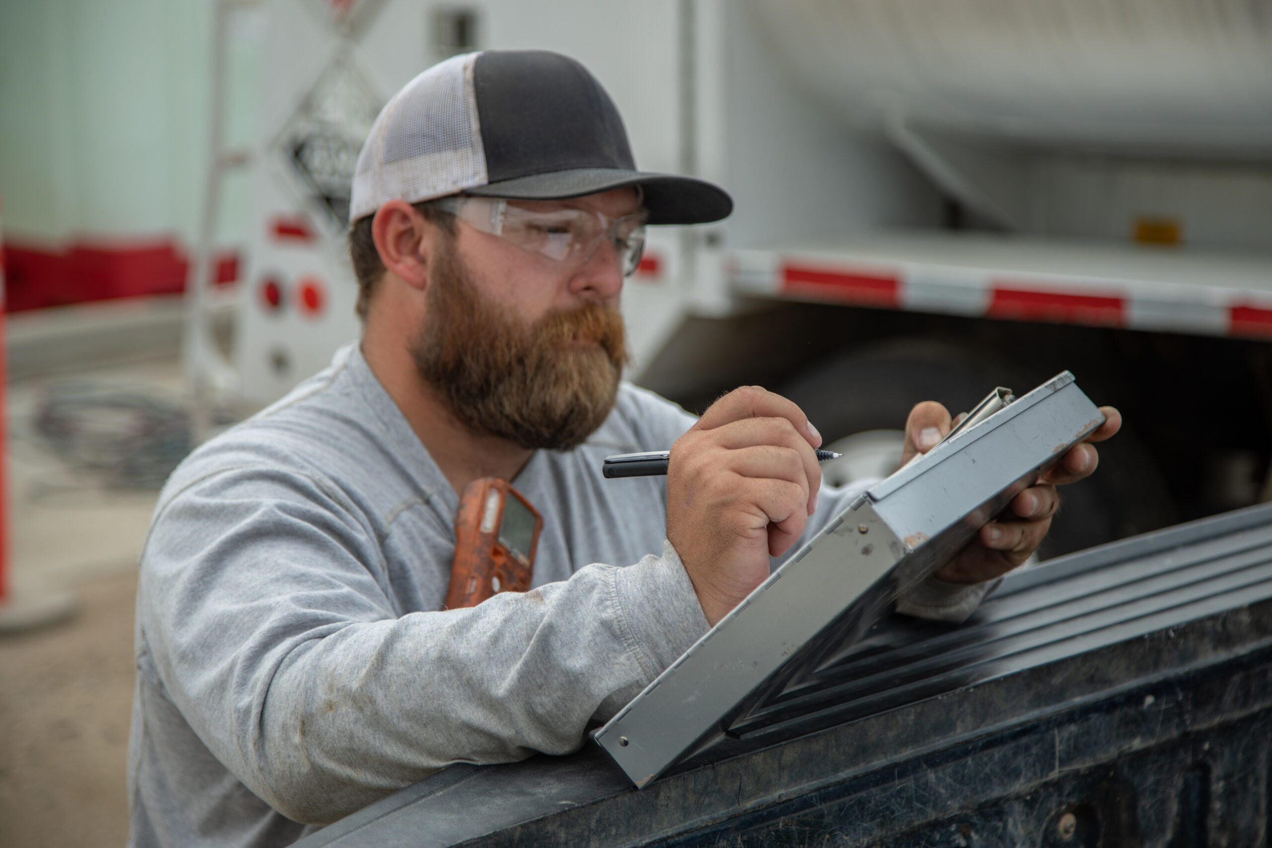 Creedence-Aug23-014 A Creedence Energy Field Service Technician records information while working on a project outside
